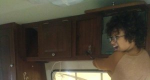 Young child using hammer to smash cabinet in RV renovation