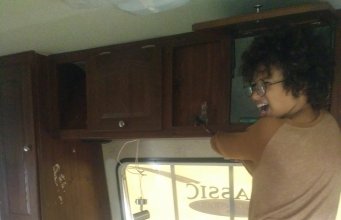 Young child using hammer to smash cabinet in RV renovation